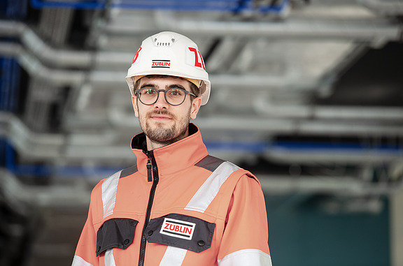 Junger Mann mit Helm lächelt in die Kamera