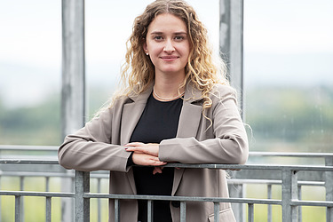 Frau steht im Büro und lächelt in die Kamera