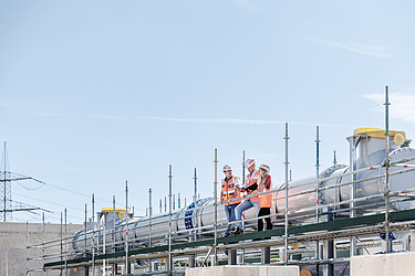 Foto von drei Personen, die auf einem Gerüst stehen 