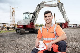 Foto von einer lächelnden Mitarbeiterin auf der Baustelle